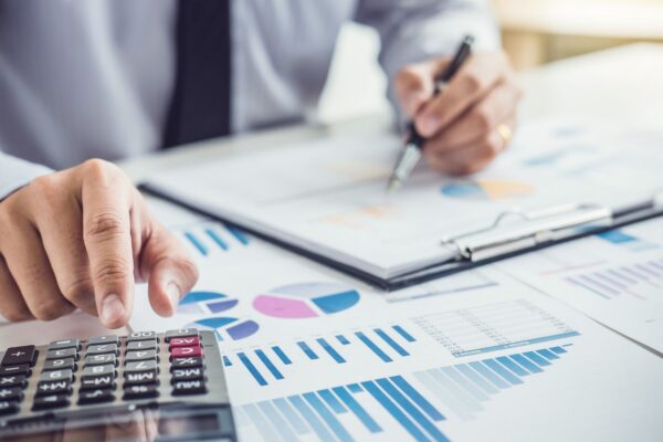 Business owner reviewing financial charts and calculations to help avoid common retirement investment mistakes.